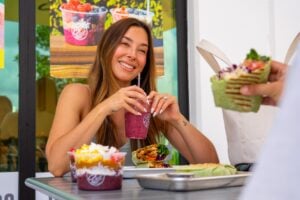 A 3Natives customer enjoys a delicious smoothie, wrap, and açaí bowl.